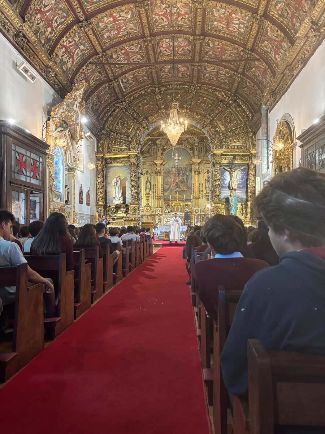 Interior da Igreja de São Pedro, com os alunos nos bancos e o celebrante junto ao altar